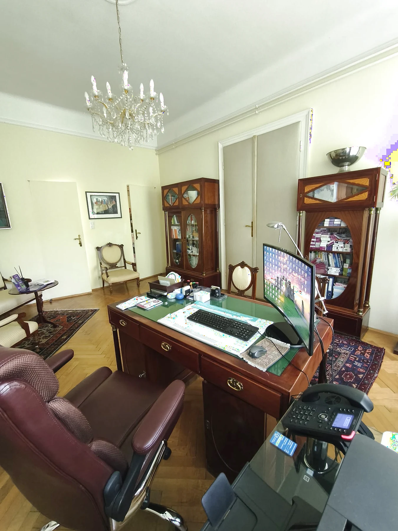 Besprechungszimmer der Ordination Dr. Fischl mit Schreibtisch, klassischem Mobiliar und medizinischer Arbeitsumgebung